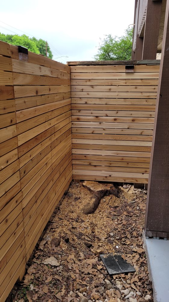 Stump ground down beside a new cedar fence